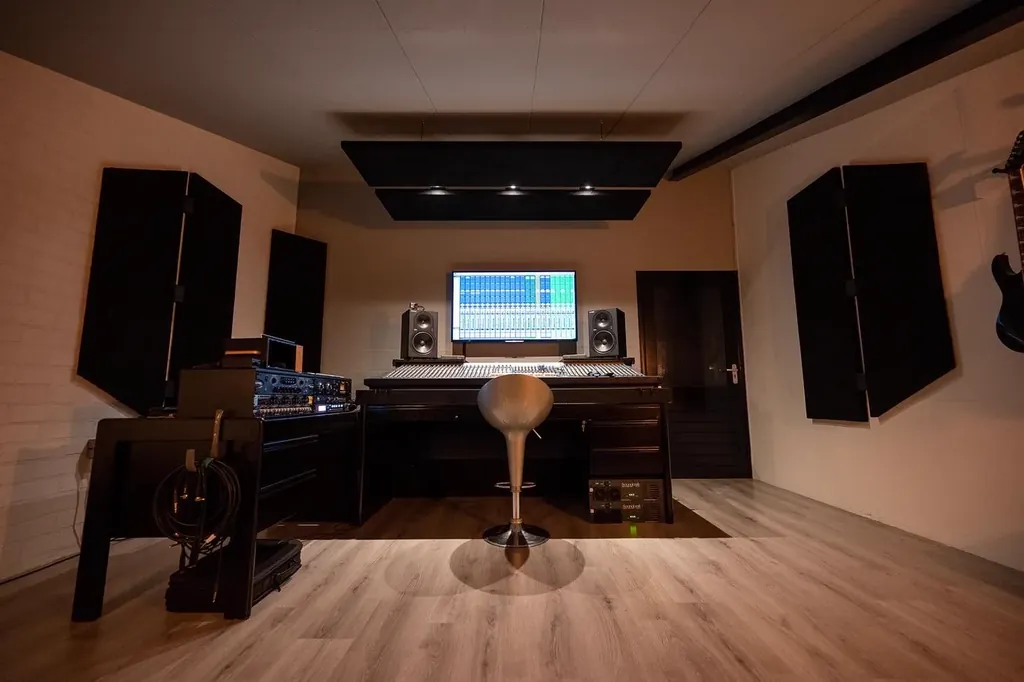 Control room at Dennis Geraads Studio with mixing console, near-field monitors, outboard racks and acoustic panels